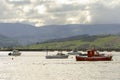 Boats moored in port with the bridge of San Vicende de la barquera, Cantabria, mountains and cloudy sky in the background Royalty Free Stock Photo