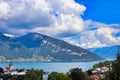 Beautiful view of buildings and lush trees on the shore of Lake Thun with mountains in the backdrop Royalty Free Stock Photo