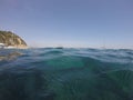 Beautiful view of the calm ocean with some sailing boats and the cliffs in the background Royalty Free Stock Photo