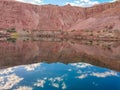 Beautiful view of a calm reflective lake and mountain under the blue cloudy sky