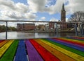 Beautiful view of the canal, bridge, painted in the colors of the LGBT community flag, church and houses in the Dutch city on a cl