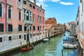 Beautiful view of canal in Venice, Italy, with boats on the water surrounded by old picturesque colorful houses under vivid blue s Royalty Free Stock Photo