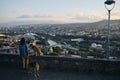 Beautiful view of the capital of Georgia Tbilisi from above from old town. A young woman with two dogs admires the