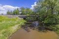 Beautiful view of cars bridge over river on green trees and blue sky with white clouds background.