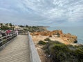 Beautiful view of the Carvoeiro Boardwalk with palm trees and cliffs along the sea in The Algarve