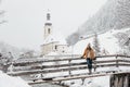 Beautiful view of a Caucasian woman standing on the fence on the frozen covered in snow background