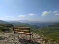 Beautiful view of the Caucasus Mountains and green hills. The bench is installed on the observation deck. Prielbrusye National Royalty Free Stock Photo