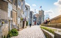 Beautiful view of the Chain and Saint Nicolas Towers and Sur-Les-Murs medieval street and tourists in La Rochelle historic center