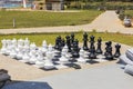 Beautiful view of chessboard with huge black and white chess pieces for outdoor play on  beach. Royalty Free Stock Photo