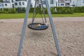 Beautiful view of child swinging on swing outdoors on playground in summer day.