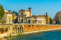 Beautiful view of colorful facades of old housesand church dei santi siro e libera on waterfront of the Adige River in Royalty Free Stock Photo