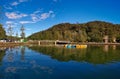 Beautiful view of creek with reflections blue sky, light clouds, fog, mountains and trees on water Royalty Free Stock Photo