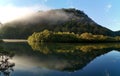 Beautiful view of creek with reflections blue sky, light clouds, fog, mountains and trees on water Royalty Free Stock Photo