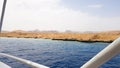 Beautiful view from the deck of a cruise ship in the Red Sea in Egypt. Egyptian rocky coast landscape with a yacht. Part of the Royalty Free Stock Photo