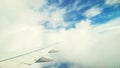 Beautiful view through the dirty window in an airplane on the wing and clouds. Royalty Free Stock Photo