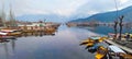 Beautiful view of docked boats on a reflective lake and a village with small houses Royalty Free Stock Photo