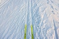 Beautiful view down at yellow plastic skis Fischer on snowy ski track.