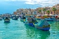 beautiful view of european harbor with village Marsaxlokk, market and traditional colorful Luzzu fishing boats, Malta