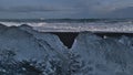 Beautiful view of famous diamond beach with black sand and strong surf in southern Iceland with iceberg.