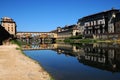 A Beautiful view of the famous Old Bridge Ponte Vecchio and Uffizi Gallery with blue sky in Florence as seen from Arno river Royalty Free Stock Photo