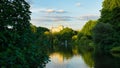 Beautiful view of the Ferris wheel, river, and trees in St James park in London, The UK