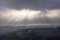 Beautiful view of the forest on hills gleaming under the sunrays piercing through the clouds Royalty Free Stock Photo