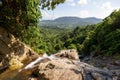 Beautiful view of a forest and mountains from the top of a waterfall Royalty Free Stock Photo