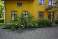 Beautiful view of frontsize of yellow wooden house whith flowers under window. Country style. Royalty Free Stock Photo