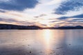 Beautiful view of the frozen river during a cold winter sunset. Winter river evening landscape with a fiery sunset and a