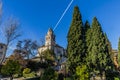 Beautiful view of a garden trees, shrubs and green plants with a church in the background Royalty Free Stock Photo