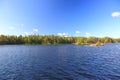Beautiful view of gorgeous nature landscape. Blue lake water and green forest on blue sky background. Sweden. Royalty Free Stock Photo