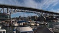 Beautiful view of Granville Street Bridge in Vancouver downtown spanning False Creek with marina and yacht boats in front.