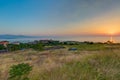 Beautiful view of the grass covered field by the ocean under the sunset captured in Lesbos, Greece Royalty Free Stock Photo