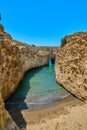 Beautiful view of Greek landscape on sunny summer day. Blue sky, azure sea, high rocky cliffs, arch, secluded bay, sandy Royalty Free Stock Photo