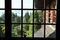 Beautiful view on green forest, blue sky and mountains through a wooden window frame of an old house cottage on a slope of a hill Royalty Free Stock Photo