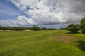 Beautiful view of green grass golf field on against blue sky with clouds background. Royalty Free Stock Photo