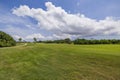 Beautiful view of green grass golf field on background blue sky with white clouds. Royalty Free Stock Photo