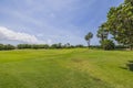 Beautiful view of green grass golf field on blue sky background on bright summer day. Royalty Free Stock Photo