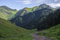 Beautiful view of green mountains with dangerous gravel road. Ketmen or Ketpen mountains gorge and mountain pass.