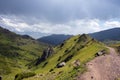 Beautiful view of green mountains with dangerous gravel road. Ketmen or Ketpen mountains gorge and mountain pass.