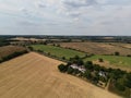 Beautiful view of harvested fields and road with green trees under the cloudy sky Royalty Free Stock Photo