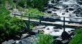 Beautiful view on the high green mountains peaks and a wooden old bridge over the river, blue sky background. Mountain hiking par Royalty Free Stock Photo