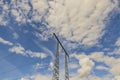 Beautiful view of high-voltage transmission line pole against blue sky with white clouds Royalty Free Stock Photo