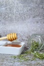 Beautiful view of honey and herbs from the woody stems of rosemary on a stone background Royalty Free Stock Photo