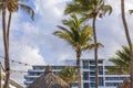 Beautiful view of hotel building with palm trees against a blue sky with white clouds. Royalty Free Stock Photo