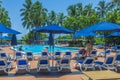 Beautiful view of of hotel grounds featuring outdoor pool, where guests unwind on sun loungers beneath umbrellas.