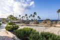 Beautiful view of hotel grounds with sandy beach, volleyball court, palm leaf umbrellas, and loungers on shore of Caribbean Sea. Royalty Free Stock Photo