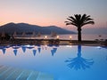 Beautiful view from the hotel terrace to the pool, palm trees folded beach tents, mountain in the distance and sunset on