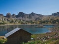 Beautiful view of a house on a shore of a lake with cliffs under the clear sky Royalty Free Stock Photo