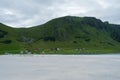 Beautiful view of houses on a mountain slope against white sand in Refviksanden Beach